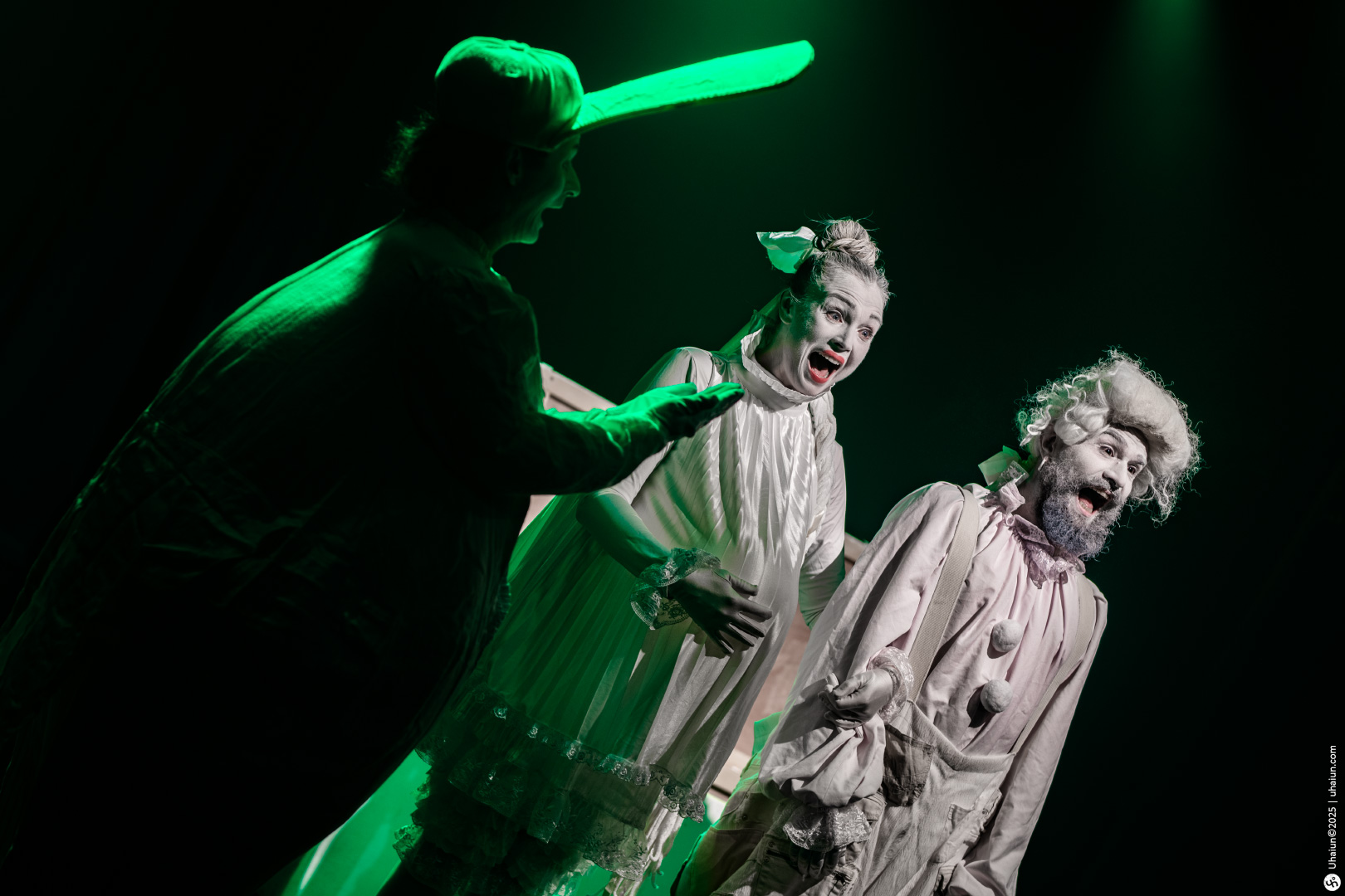 Theatrical actors performing in dramatic costumes onstage