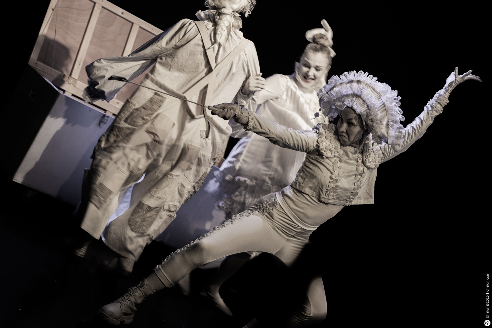 Theatrical performers in imaginative white costumes dance