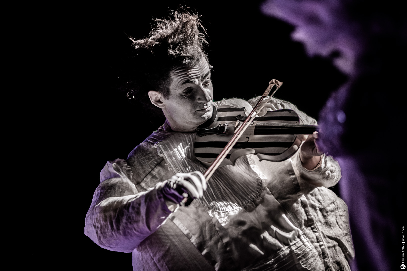 Violinist performs passionately on stage in costume