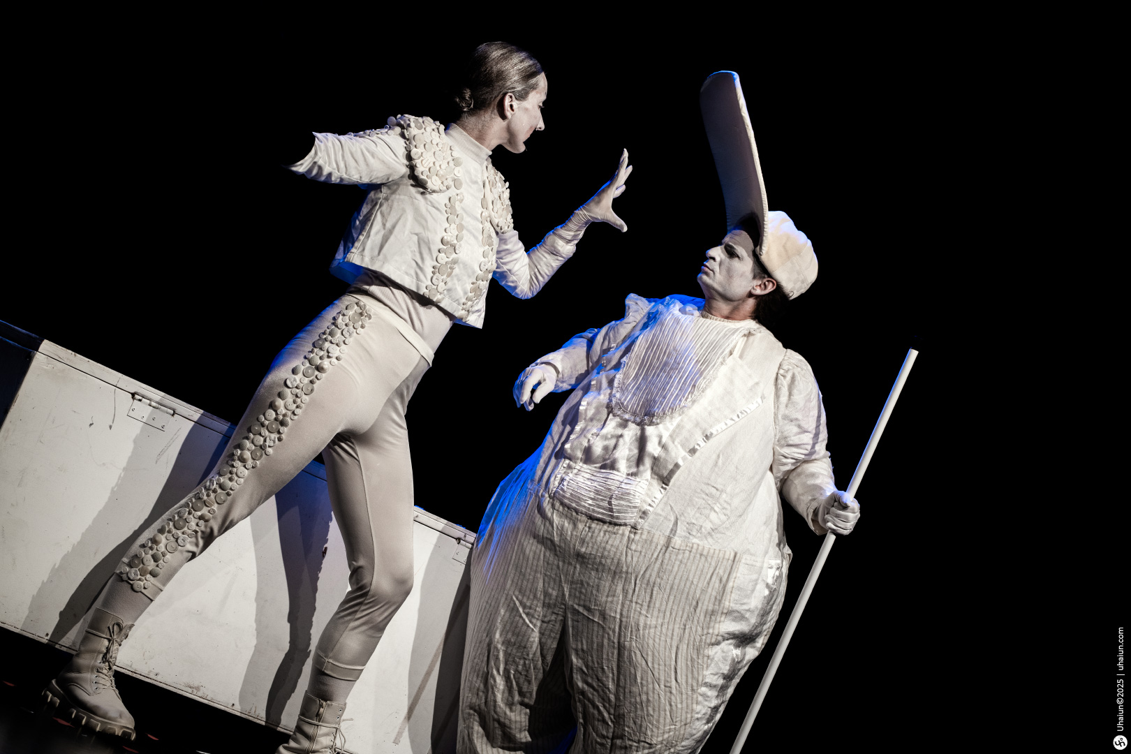 Two performers in theatrical costumes on stage