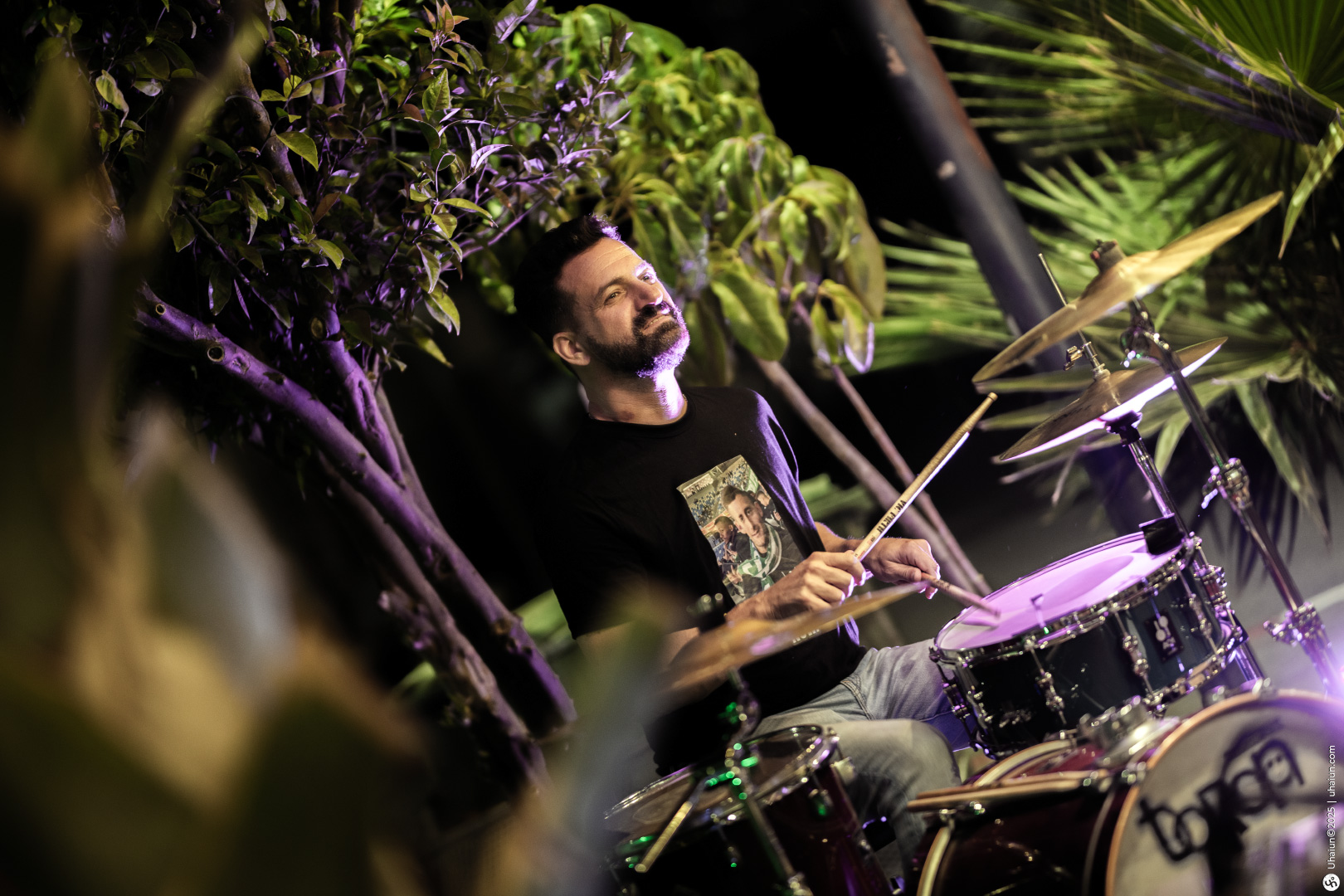 Man playing drums in a tropical setting