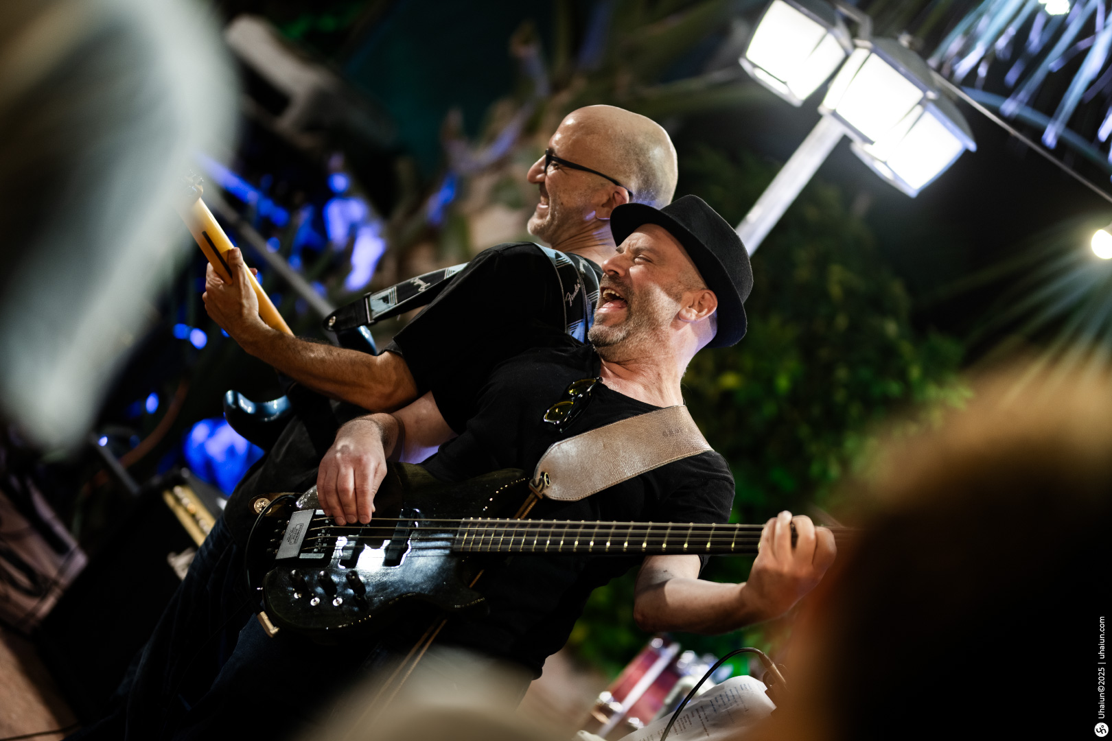 Musicians performing energetically at outdoor concert event