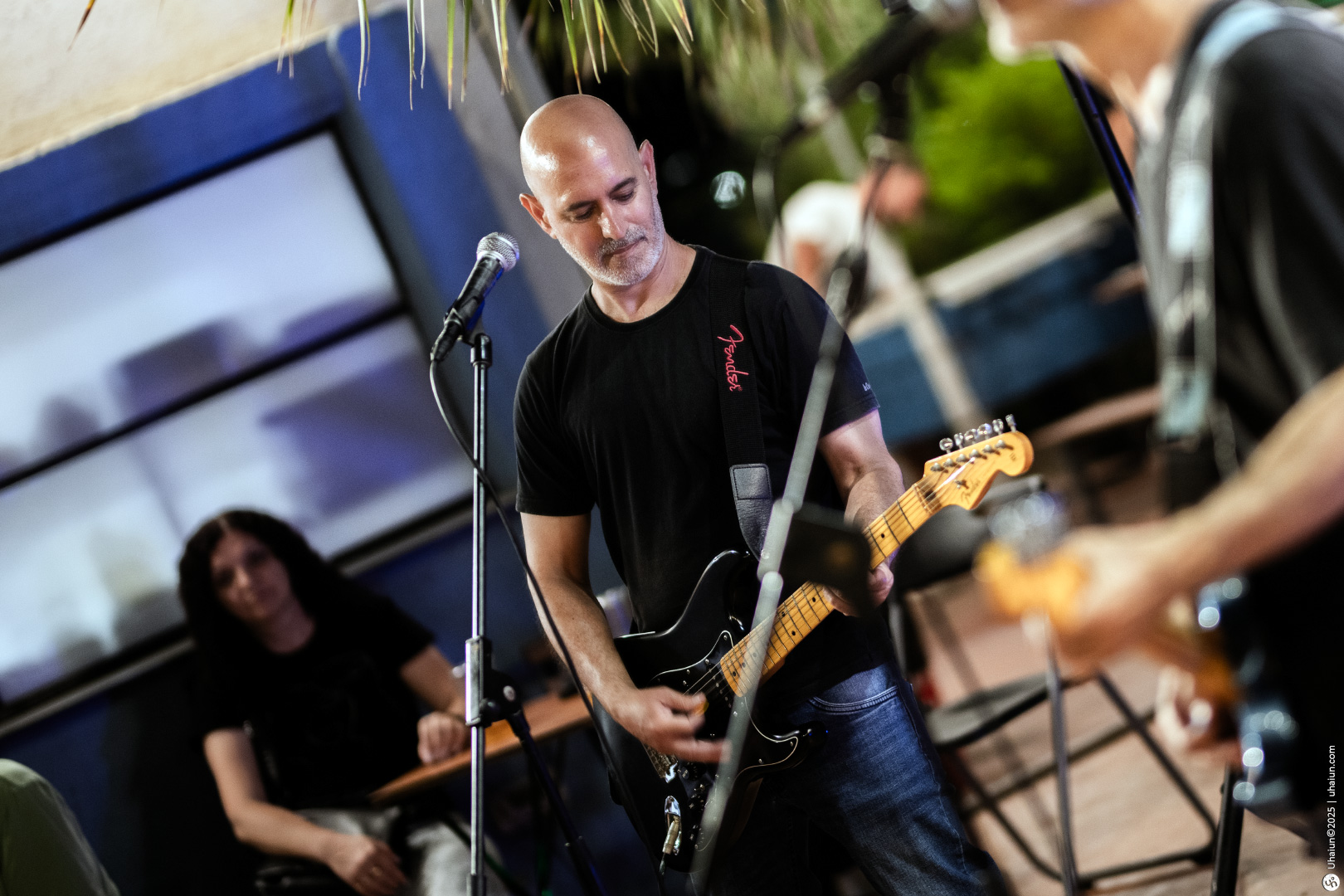 Musician performing outdoor concert with electric guitar