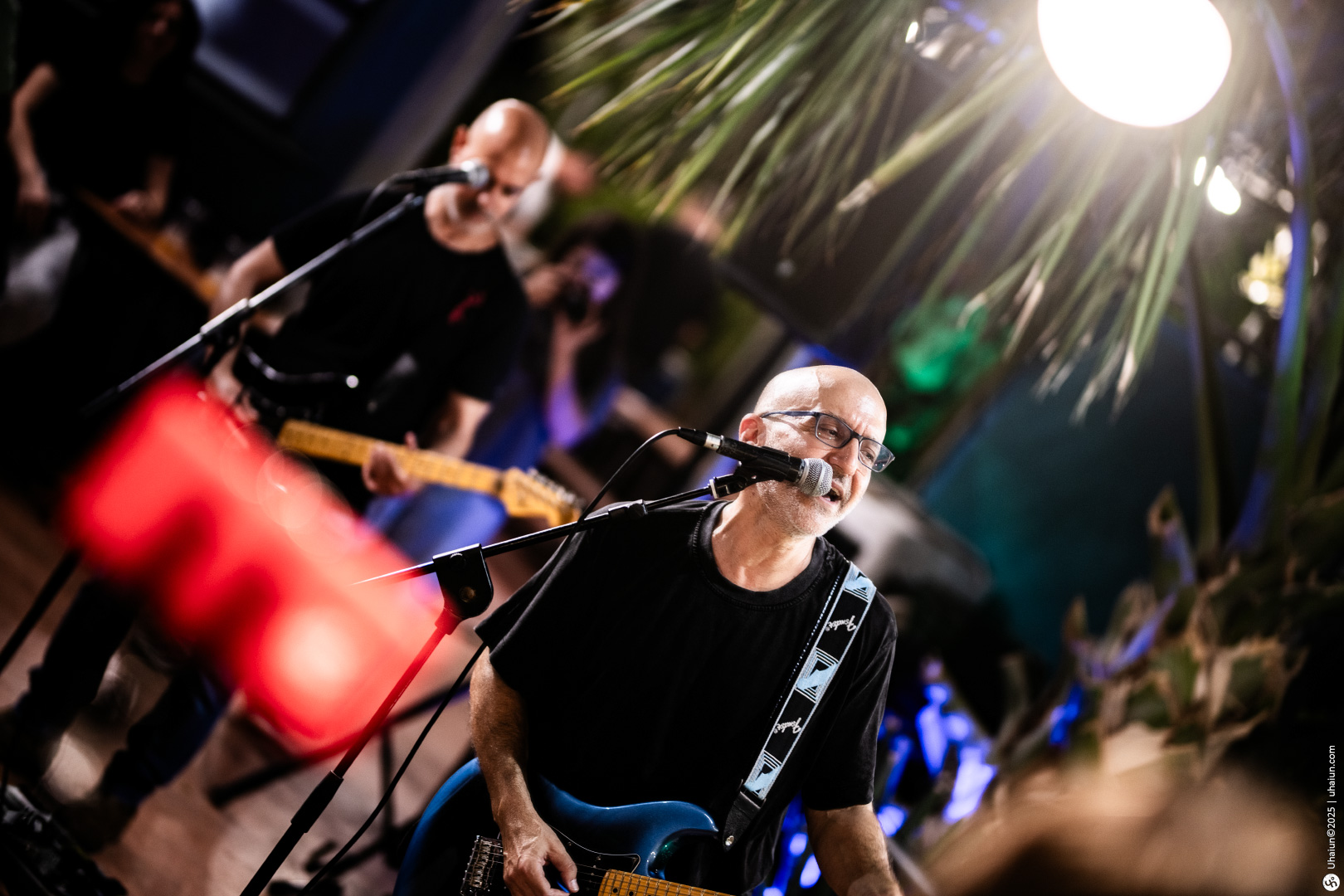 Musicians performing live on stage with guitars