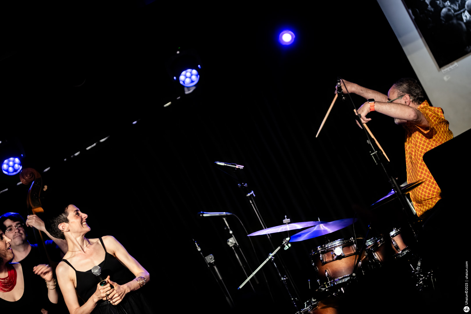 Musicians performing energetically on a dimly-lit stage