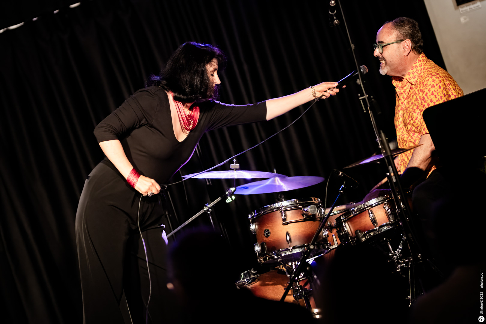 Musical performance with singer and drummer on stage