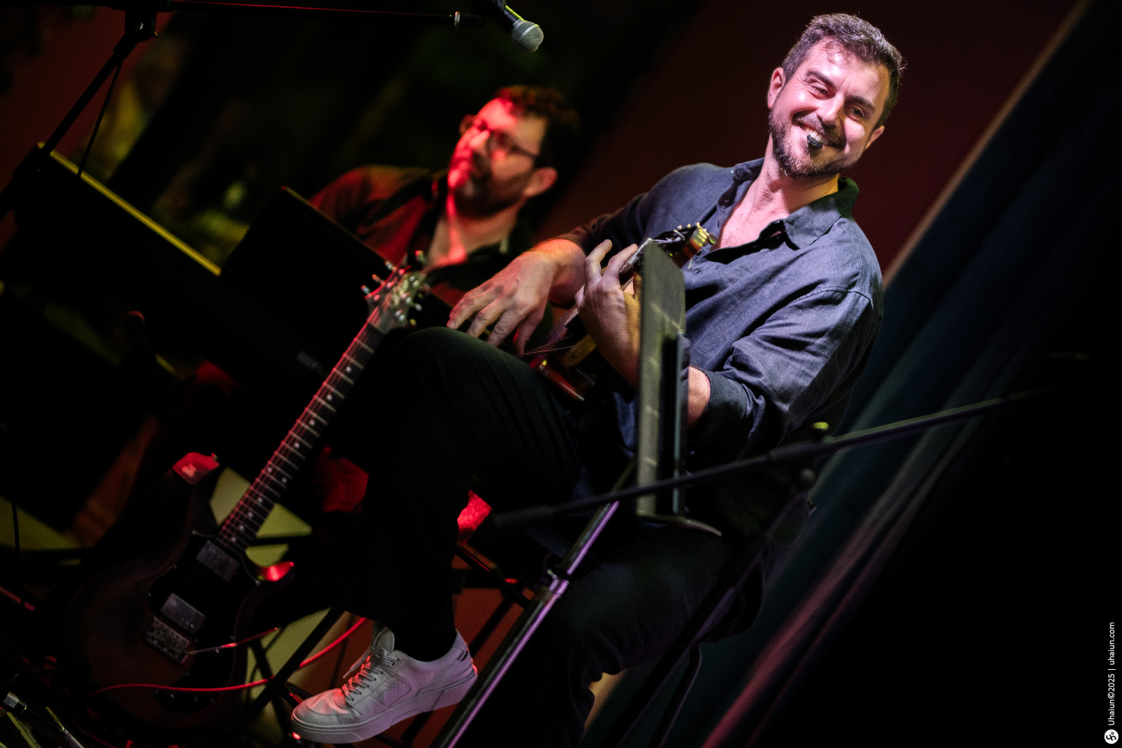 Musicians performing live on stage with guitars