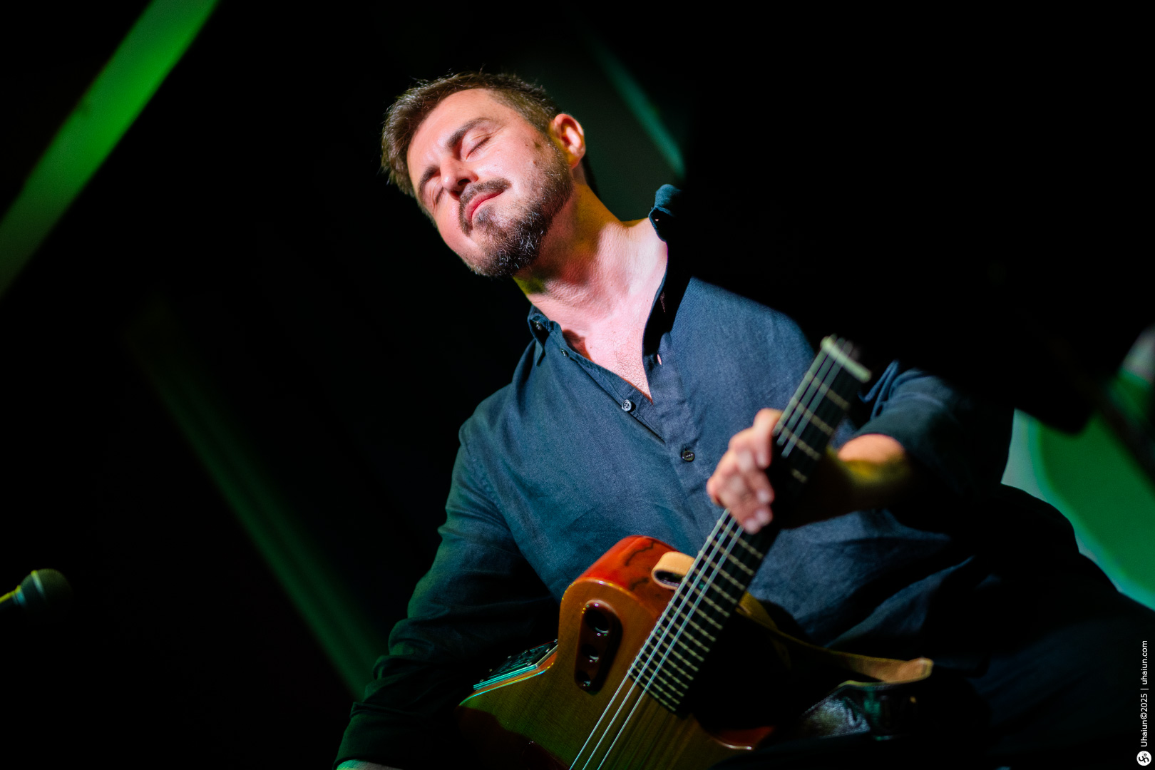 Man passionately playing acoustic guitar on stage