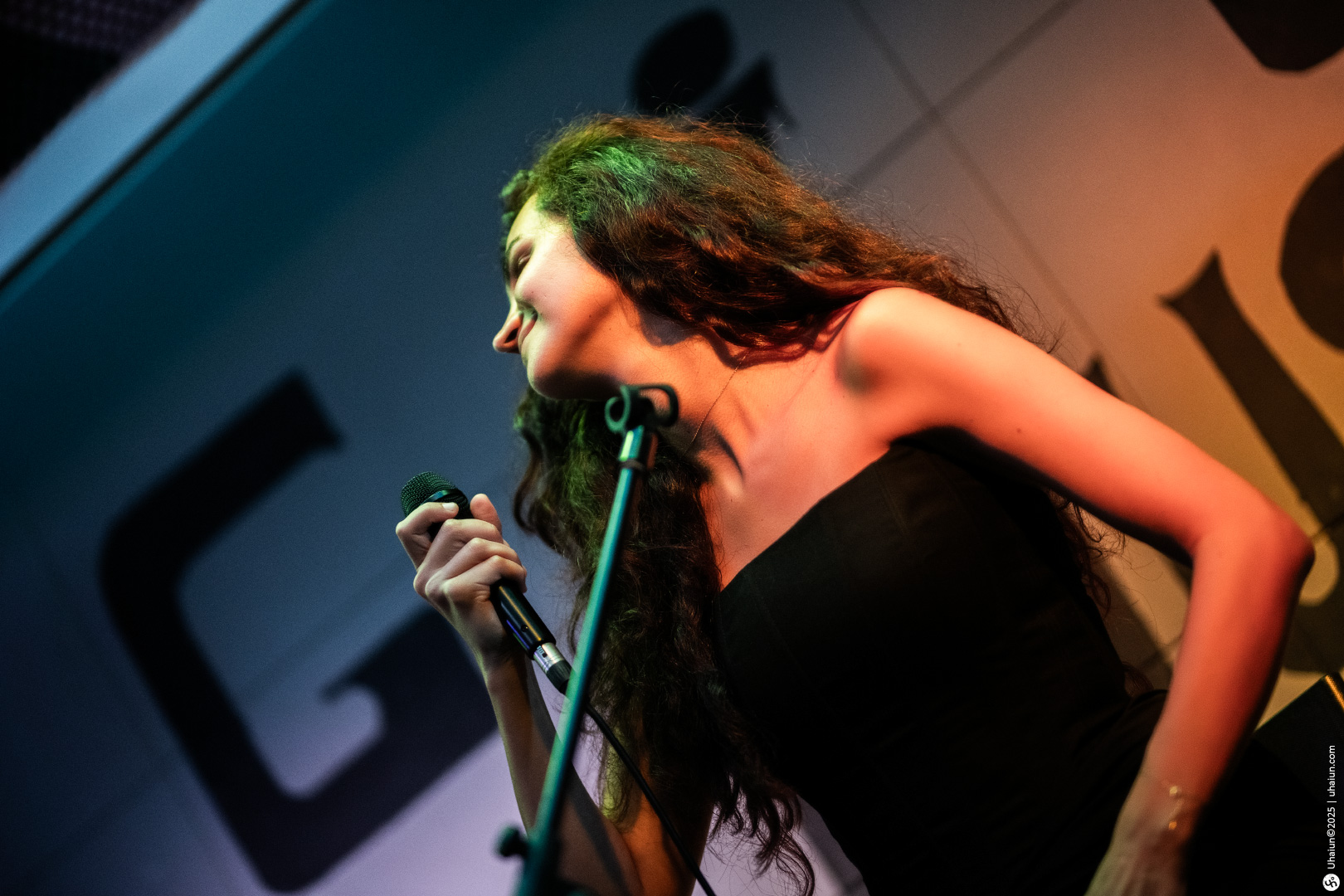Singer performing on stage under colorful lights