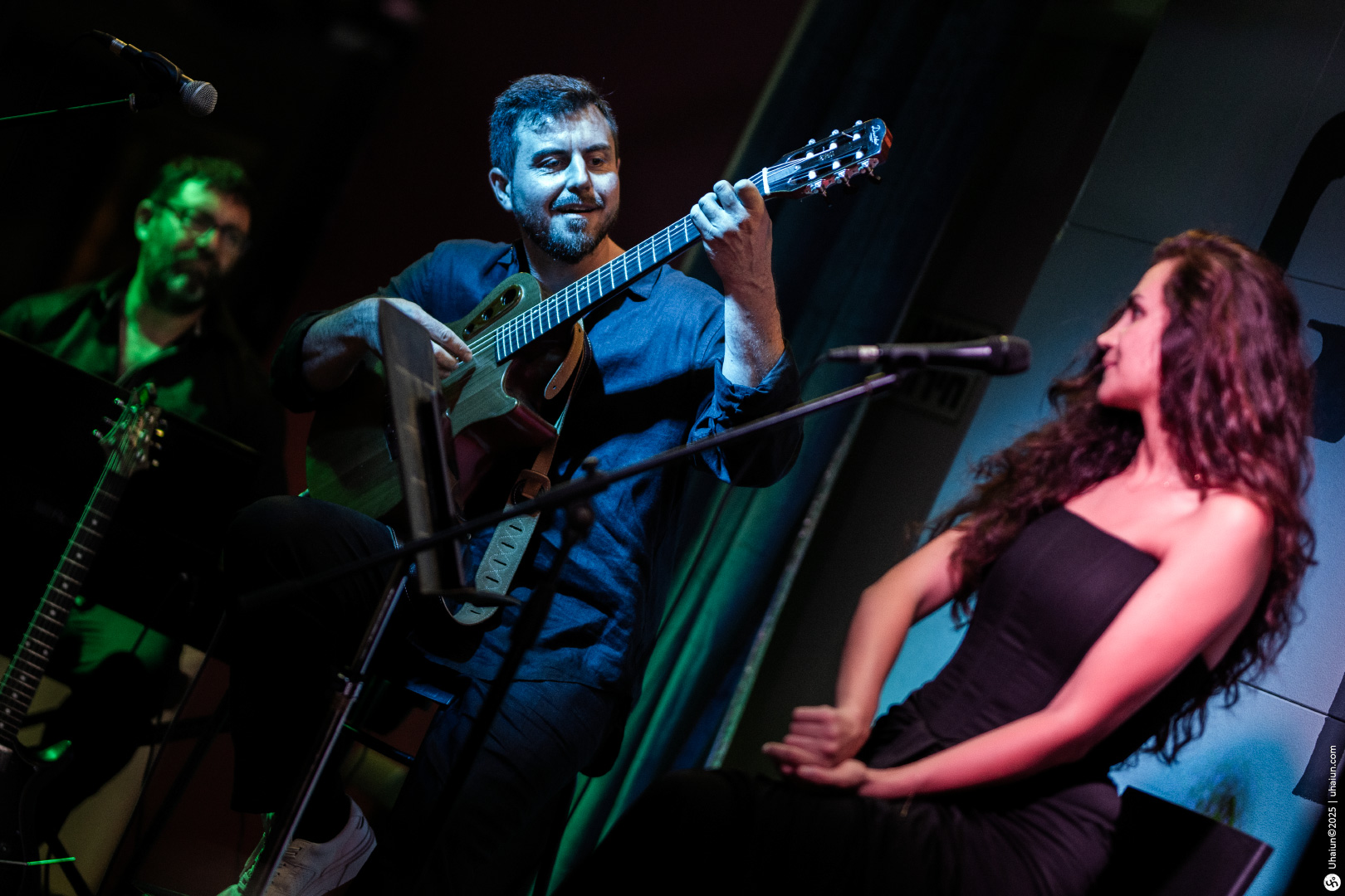 Musicians performing live on stage with guitar