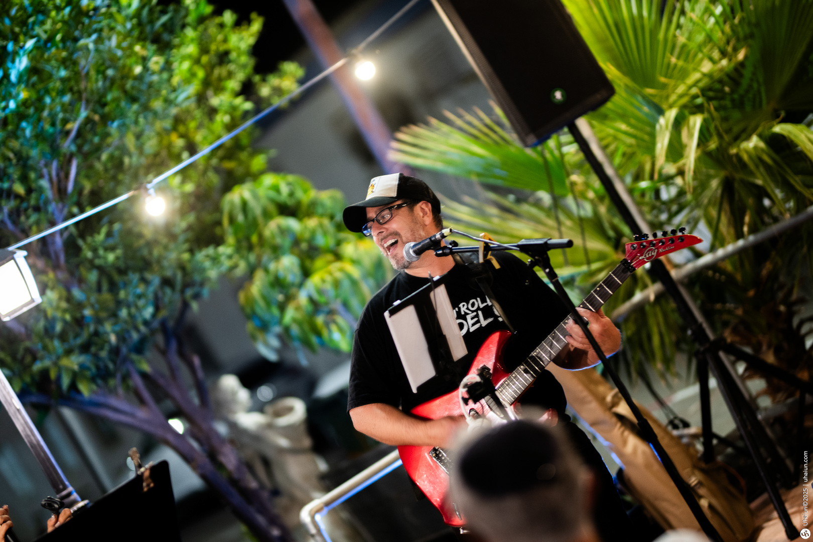 Guitarist performing energetically outdoors at night event