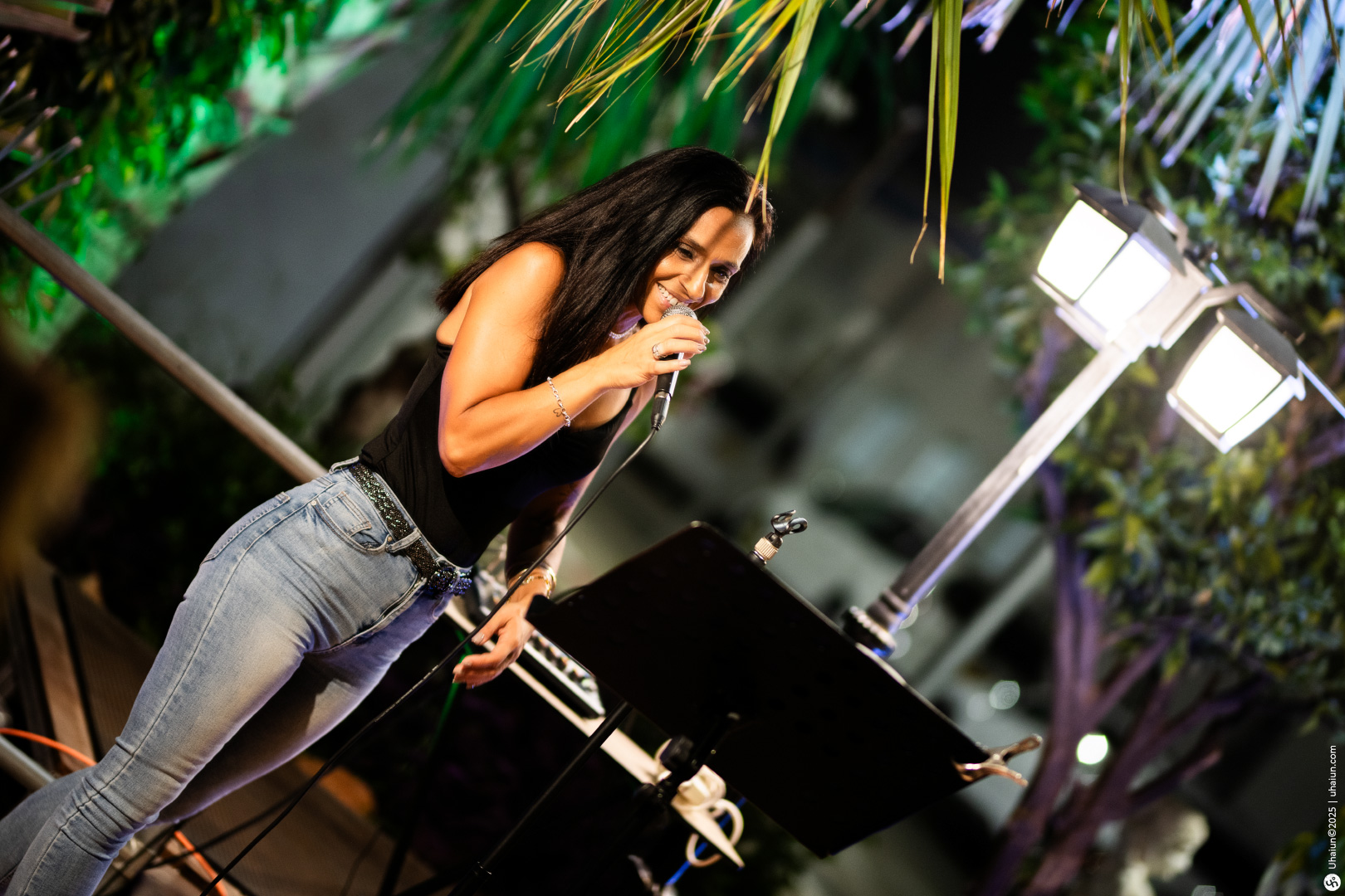 Woman singing passionately on outdoor stage at night