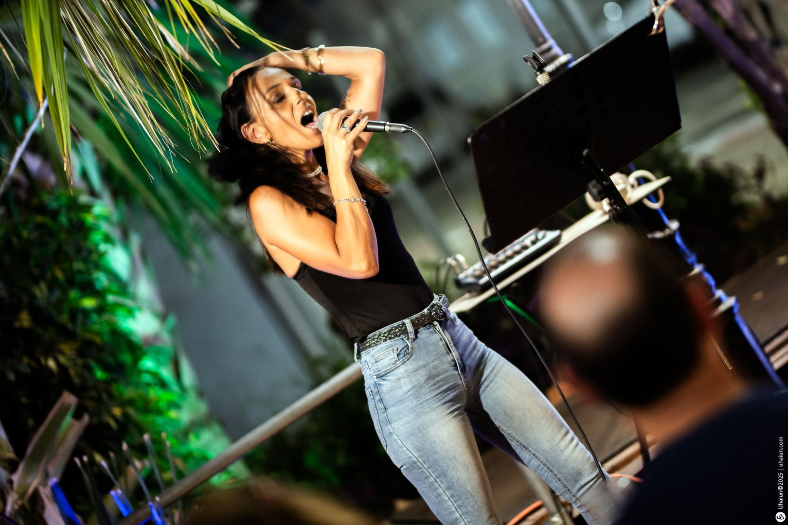 Woman passionately singing at outdoor event stage