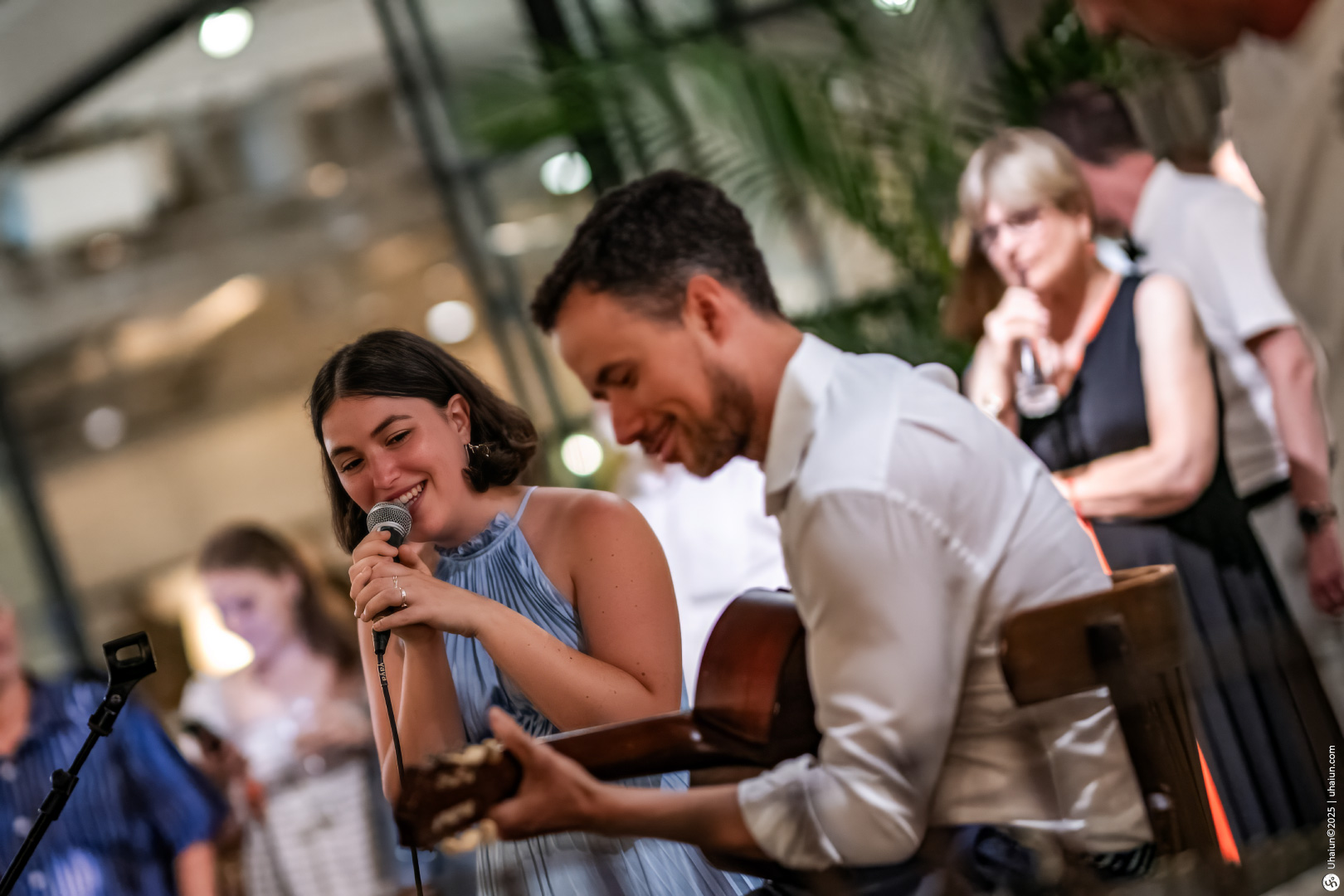 Musician playing guitar with people watching performance