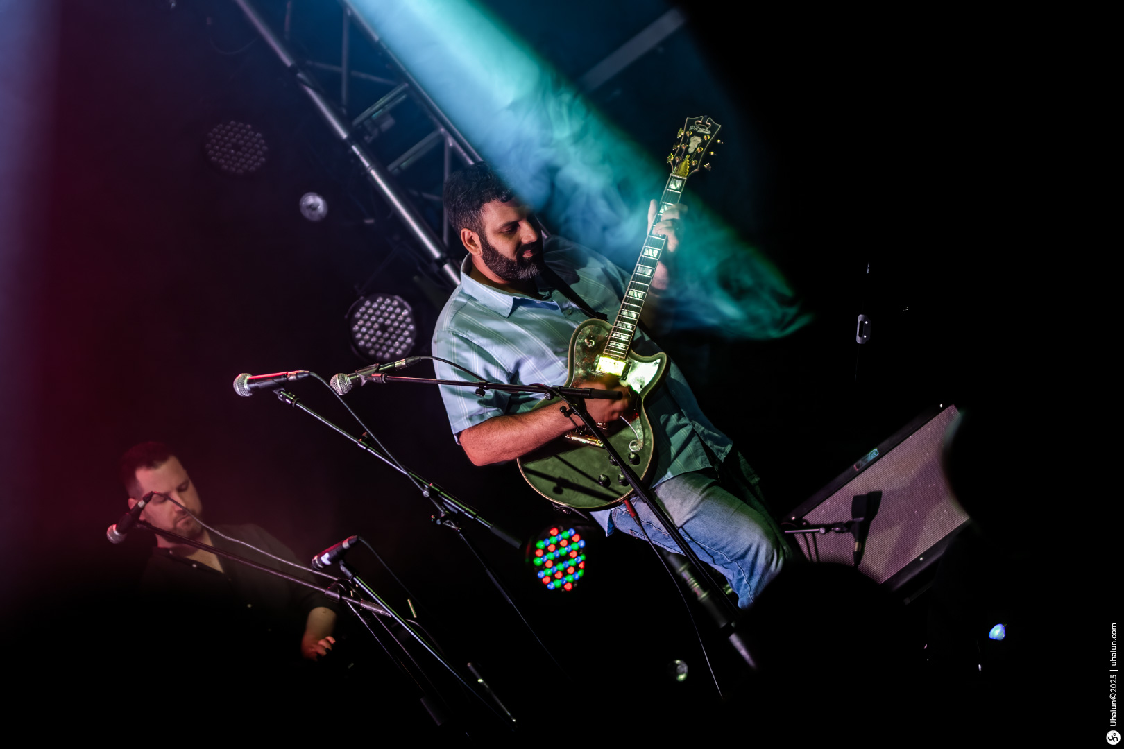 Guitarist performing live on stage with lights