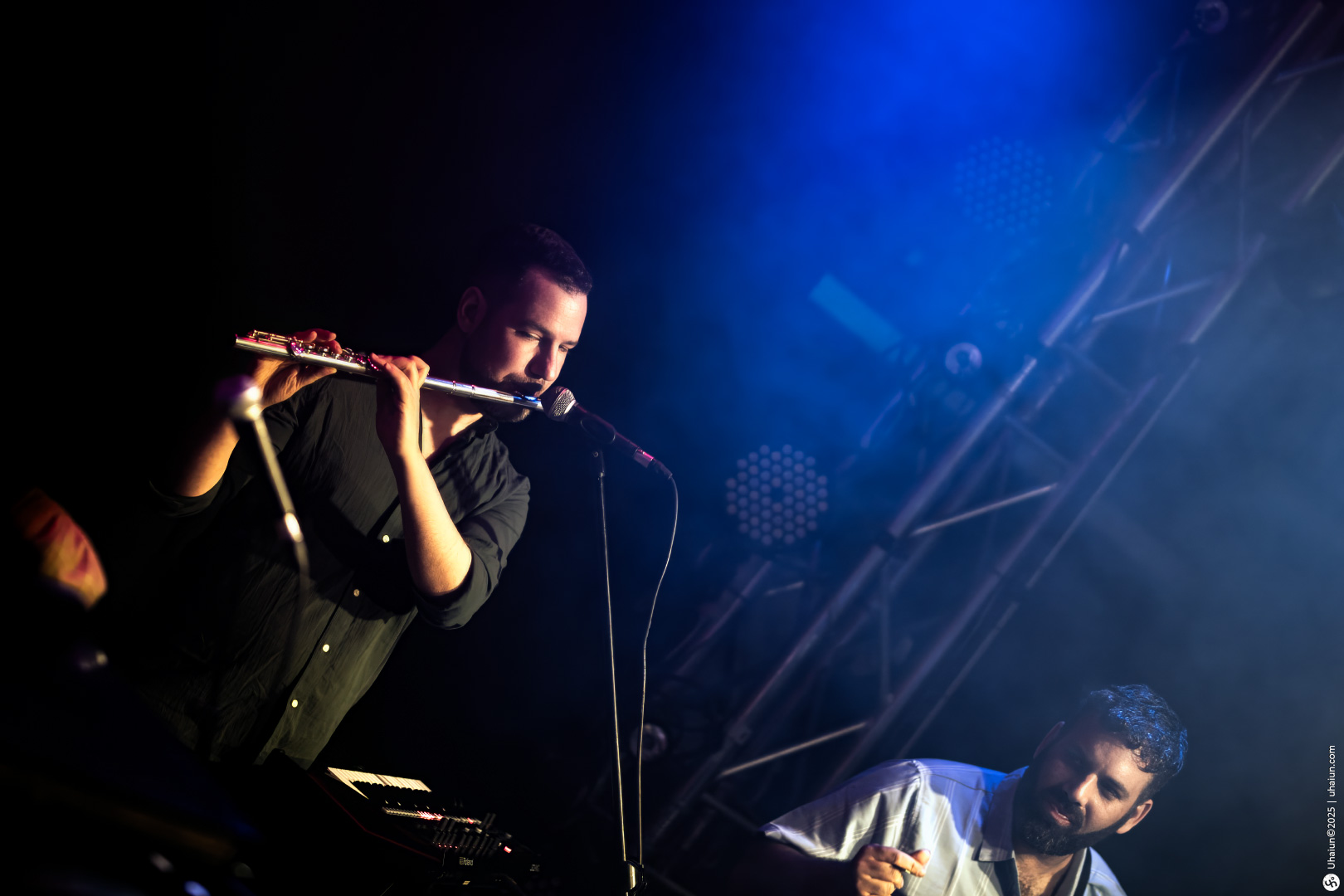 Musicians performing live on stage with flute