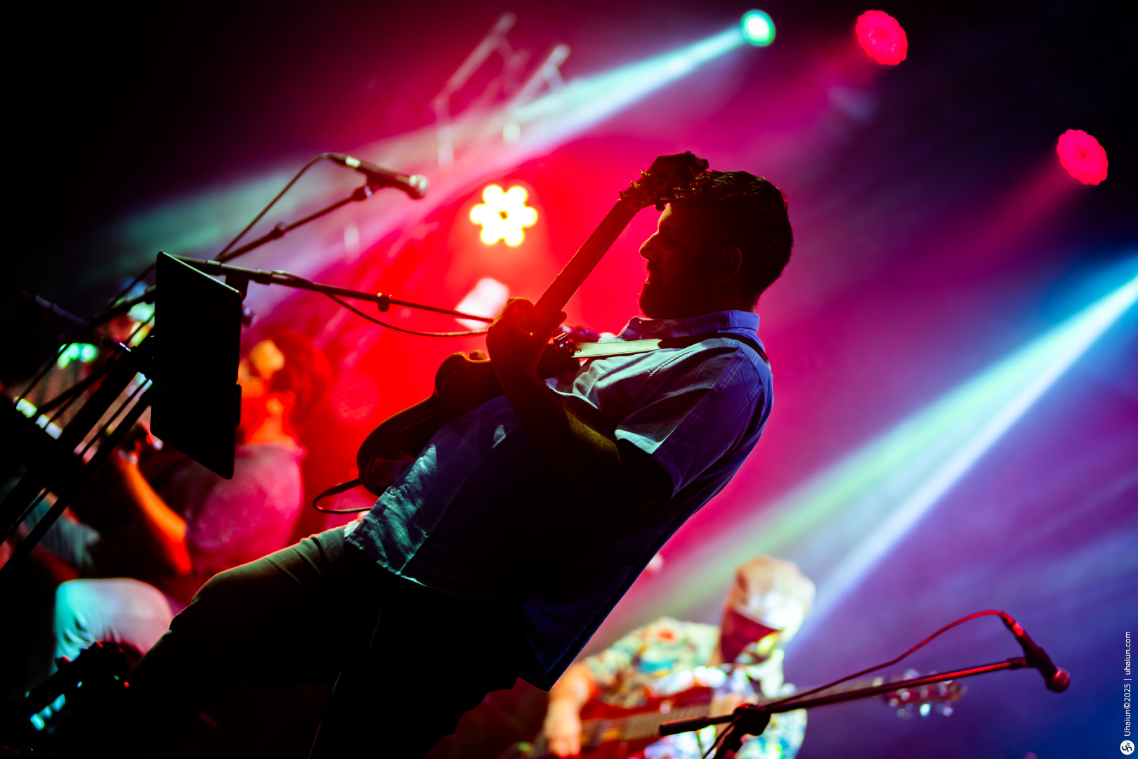 Guitarist performing live on stage with lights