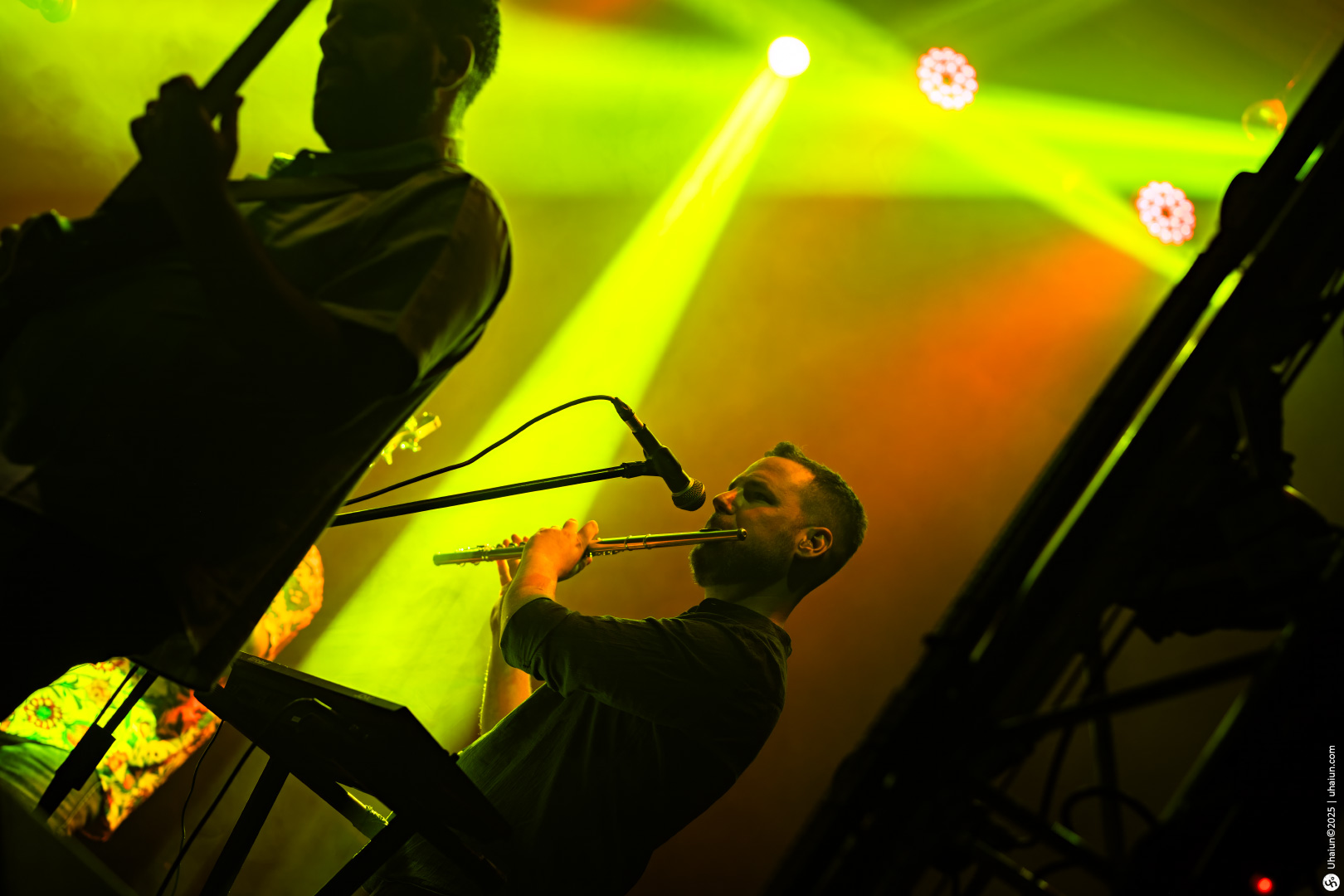 Musician performing with flute on stage brightly