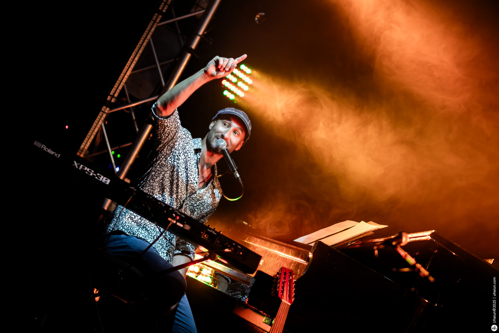 Musician performing energetically on stage with keyboard